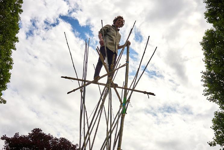 A performer atop of bamboo