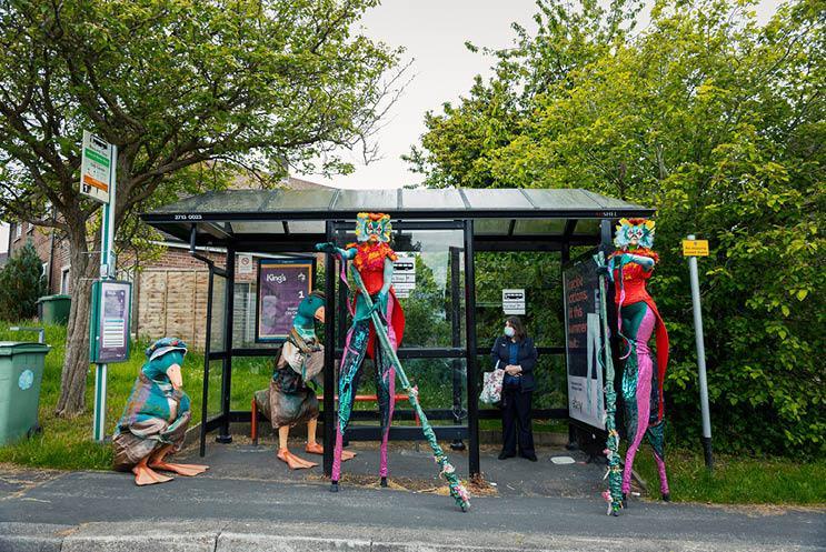 people is costume at bus stop